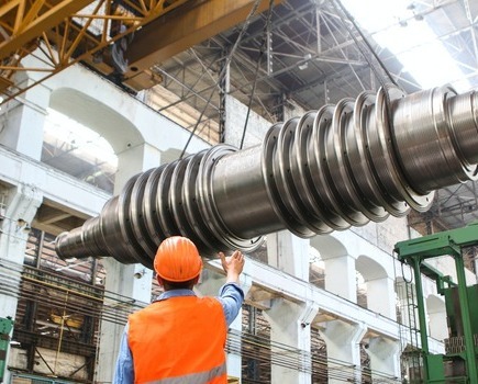 Construction workers manouvering a large and heavy piece of machinery